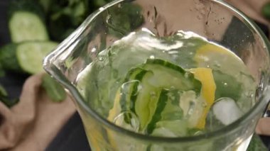 İçindekiler taze salatalık suyuyla testiye dökülüyor, yakın plan.