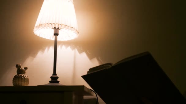 夜に家で本を読んだ後 女性は光を消す — ストック動画