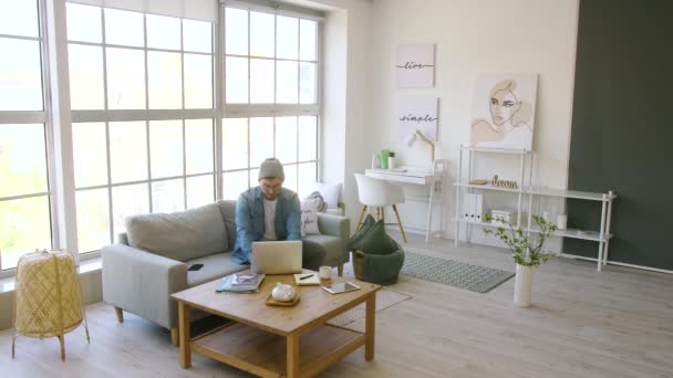 一个英俊的年轻人在家里工作时喝咖啡休息 — 图库视频影像