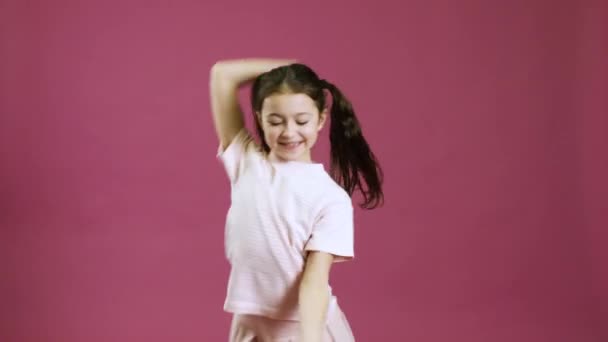 可爱的小女孩在彩色背景下跳舞 — 图库视频影像