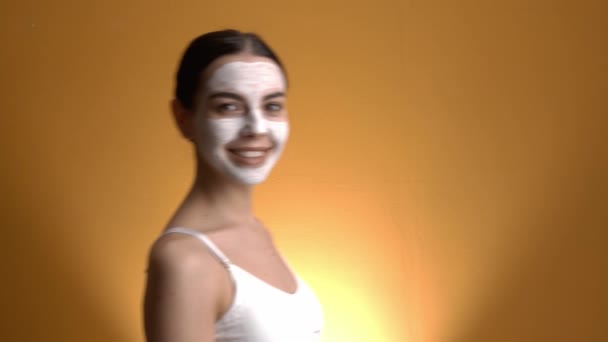 Mooie Jonge Vrouw Met Komkommer Slice Gezichtsmasker Kleur Achtergrond — Stockvideo