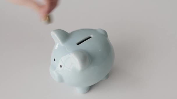 Frau Legt Münzen Sparschwein Auf Weißem Tisch Schuldenkonzept — Stockvideo