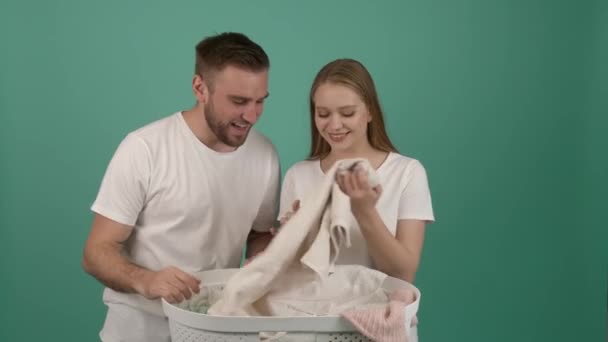 Pareja Feliz Con Ropa Limpia Cesta Sobre Fondo Color — Vídeo de stock