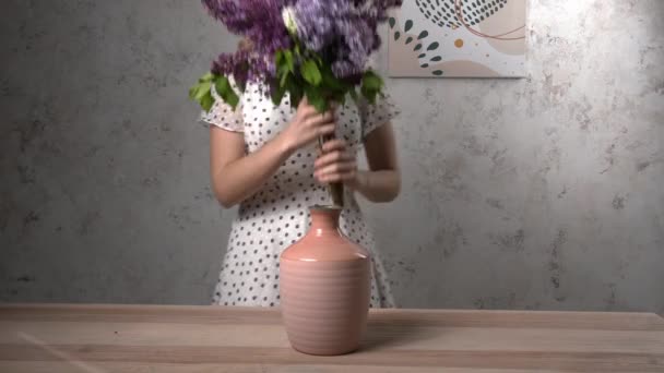 Vrouw Zetten Mooie Lila Bloemen Vaas Thuis — Stockvideo