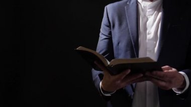 Karanlık arka planda İncil 'i olan adam.