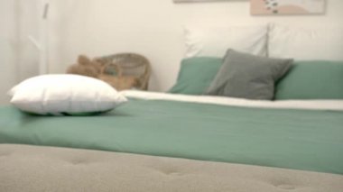 Kadın odadaki yatak başucundaki bankın üzerine hava sazlığı ayırıcı koyuyor.