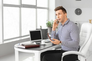 Ofiste çalışan yakışıklı iş adamı.