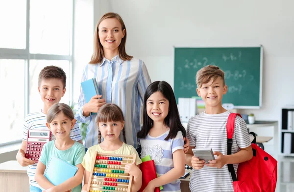 Children with math teacher during lesson in classroom