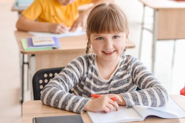 Sınıfta matematik ödevi yapan küçük kız.