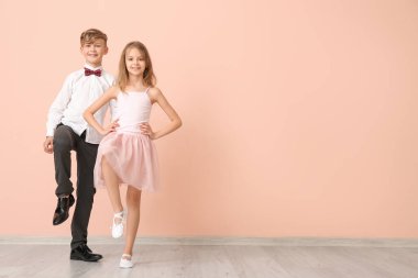 Renk duvarında dans eden şirin çocuklar.