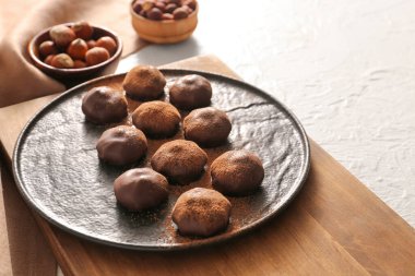 Beyaz arka planda lezzetli çikolata şekerleri olan bir tabak.