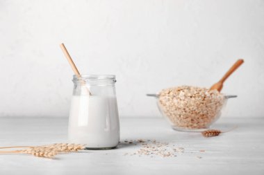 Beyaz masada bir kavanoz lezzetli yulaf sütü.