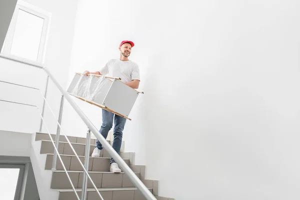Loader carrying furniture in the stairway