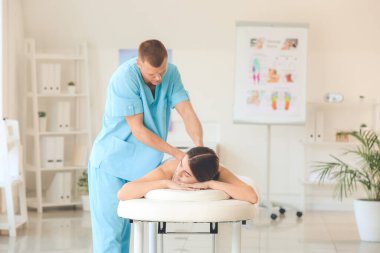 Tıp merkezinde kadın hastayla çalışan masaj terapisti.