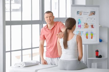 Tıp merkezinde kadın hastayla çalışan masaj terapisti.