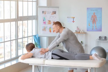 Tıp merkezinde kadın hastayla çalışan masaj terapisti.