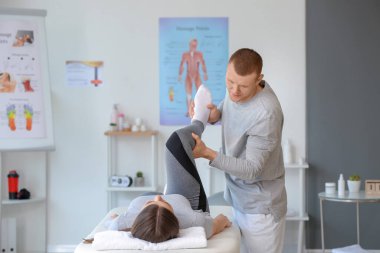 Tıp merkezinde kadın hastayla çalışan masaj terapisti.