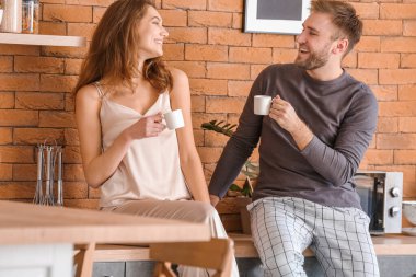 Mutfakta kahve içen mutlu çiftin sabahı.