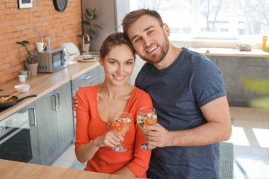 Mutfakta şarap içen mutlu genç çift.