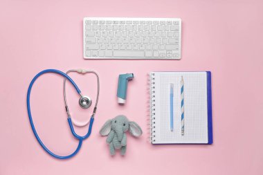 PC klavye, steteskop, kırtasiye, astım spreyi ve renk arka planında oyuncak