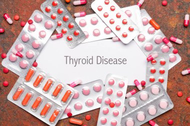Text THYROID DISEASE with pills on color background clipart