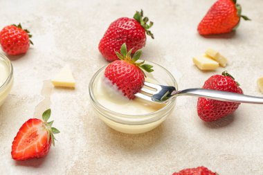 Gri arka planda erimiş çikolatalı lezzetli çilek.