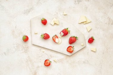 Hafif arka planda lezzetli çilekli ve erimiş çikolatalı pano.