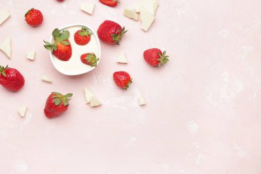 Lezzetli çilekli kase ve arka planda erimiş çikolata.