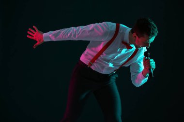 Genç adam sahnede şarkı söylüyor.