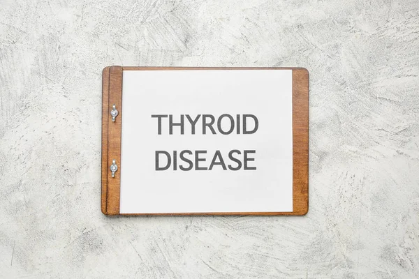 Clipboard with text THYROID DISEASE on light background