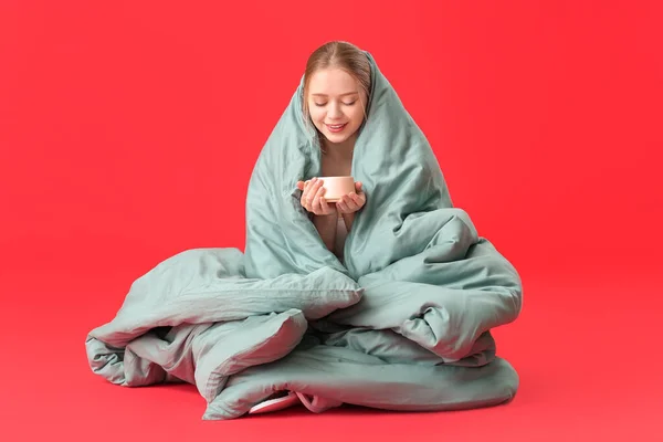 Junge Frau Decke Gehüllt Trinkt Tee Auf Farbigem Hintergrund — Stockfoto