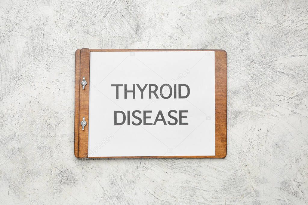 Clipboard with text THYROID DISEASE on light background