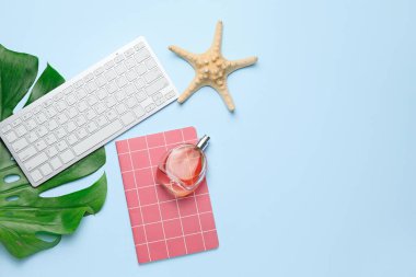 Not defteri, parfüm şişesi ve deniz yıldızlı bilgisayar klavyesi