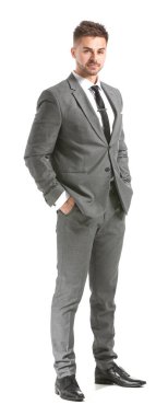 Beyaz arka planda zarif takım elbiseli yakışıklı bir genç.