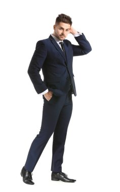 Beyaz arka planda zarif takım elbiseli yakışıklı bir genç.