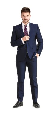 Beyaz arka planda zarif takım elbiseli yakışıklı bir genç.