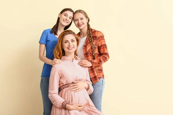 色の背景にレズビアンのカップルと妊婦 代理出産の概念 — ストック写真