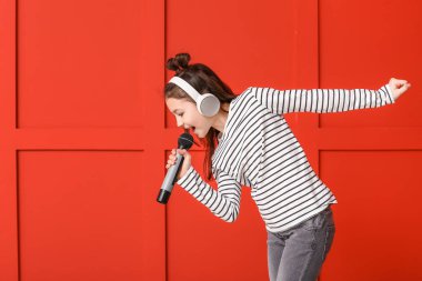 Renkli arka planda şarkı söyleyen tatlı küçük kız.