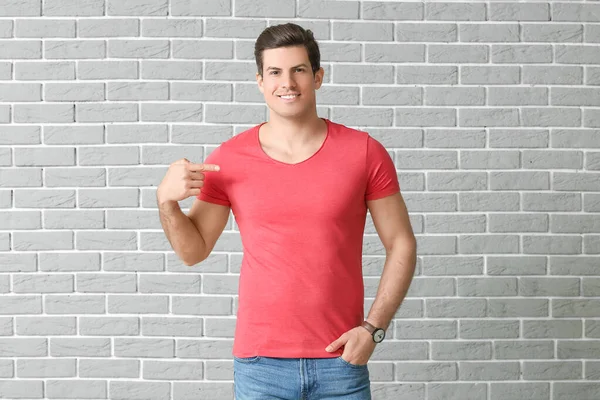 男でスタイリッシュなTシャツでレンガの背景 — ストック写真