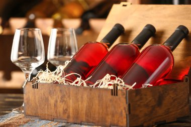 Bodrumdaki masada şarap ve bardaklarla dolu bir kutu.