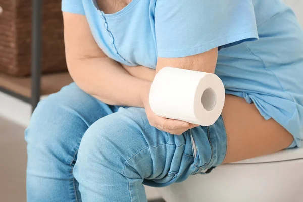 トイレの便器に座っている痔を持つ高齢女性 — ストック写真