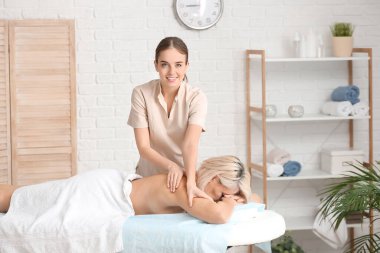 Tıp merkezinde kadın hastayla çalışan masaj terapisti.