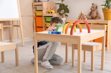 Küçük çocuk evde oynuyor.