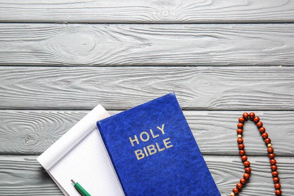 stock image Holy Bible, notebook and rosary beads on wooden background