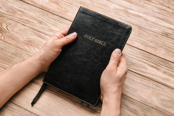 Manos Hombre Con Biblia Sobre Fondo Madera —  Fotos de Stock