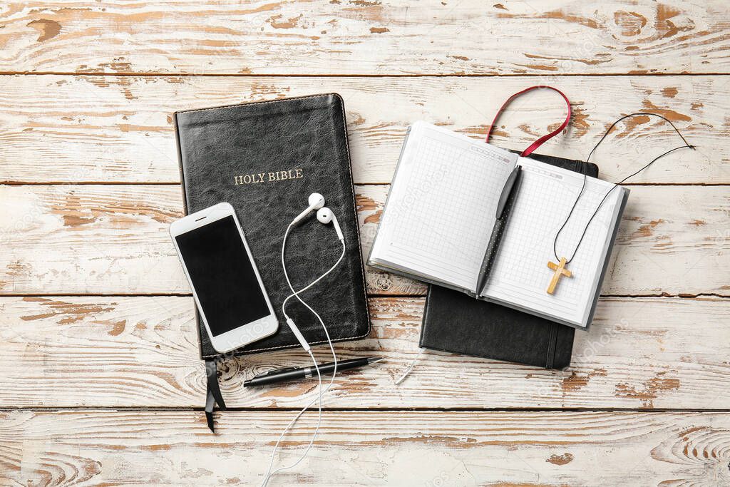 Composition with Holy Bible and mobile phone on wooden background