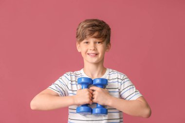 Renkli arka planda dambılları olan sportif küçük çocuk.
