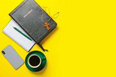 Kutsal İncil, bir fincan kahve ve renkli cep telefonu.