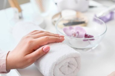 Kadın güzellik salonunda profesyonel manikür yaptırıyor.