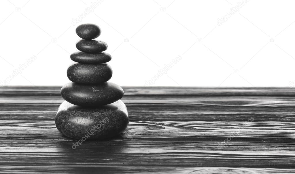 Zen stones on table against white background